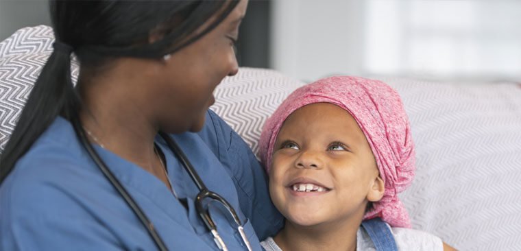 Healthcare worker looking at a child smiling back at her